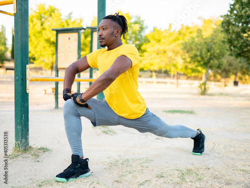 Sportsman stretching leg while exercising at park photo