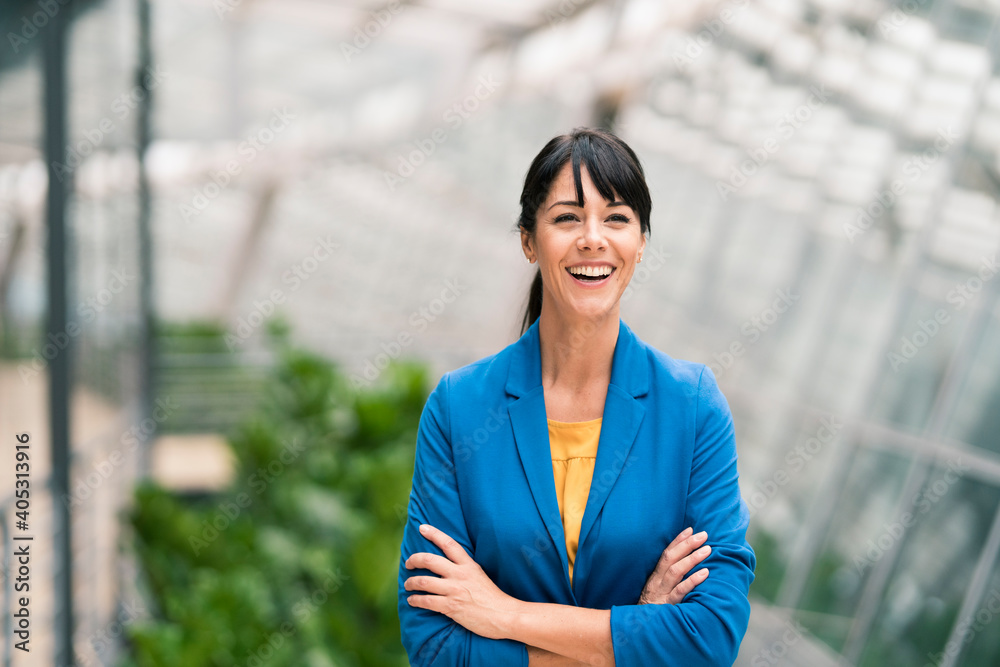 Happy businesswoman with arms crossed in office Happy businesswoman with arms crossed in office
