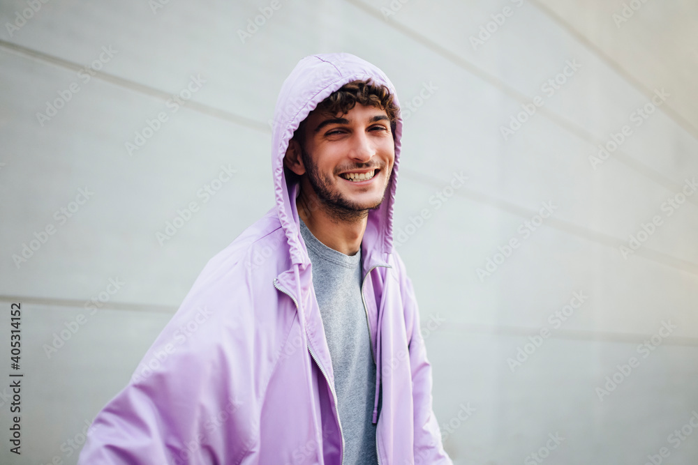 Smiling man in violet jacket against gray wall Smiling man in violet jacket against gray wall