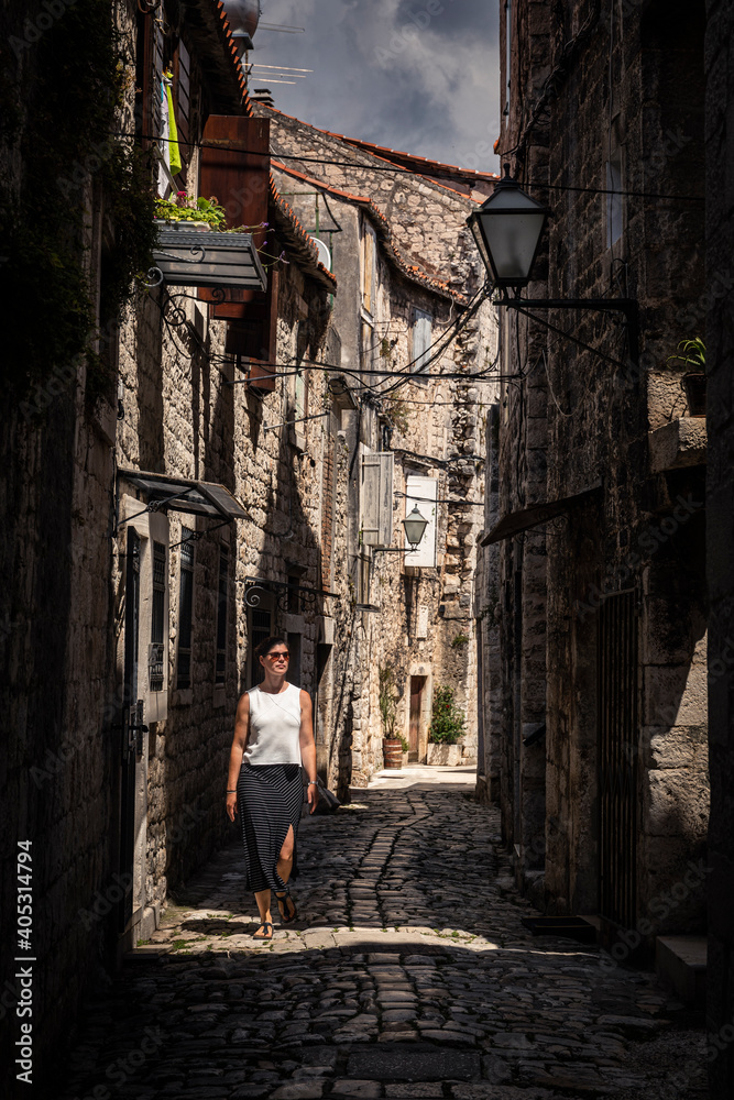 Woman walking on narrow alley in old town Woman walking on narrow alley in old town