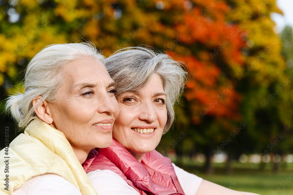 Smiling mature female friends at public park Smiling mature female friends at public park