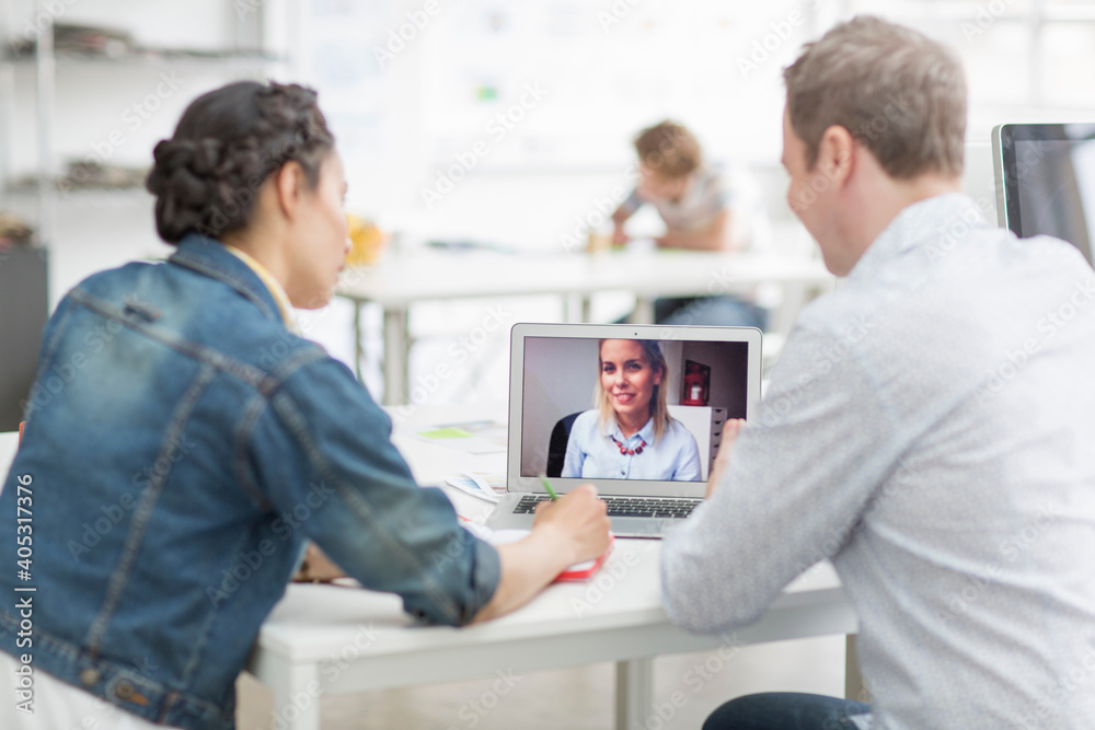 Colleagues using laptop in meeting at desk Colleagues using laptop in meeting at desk