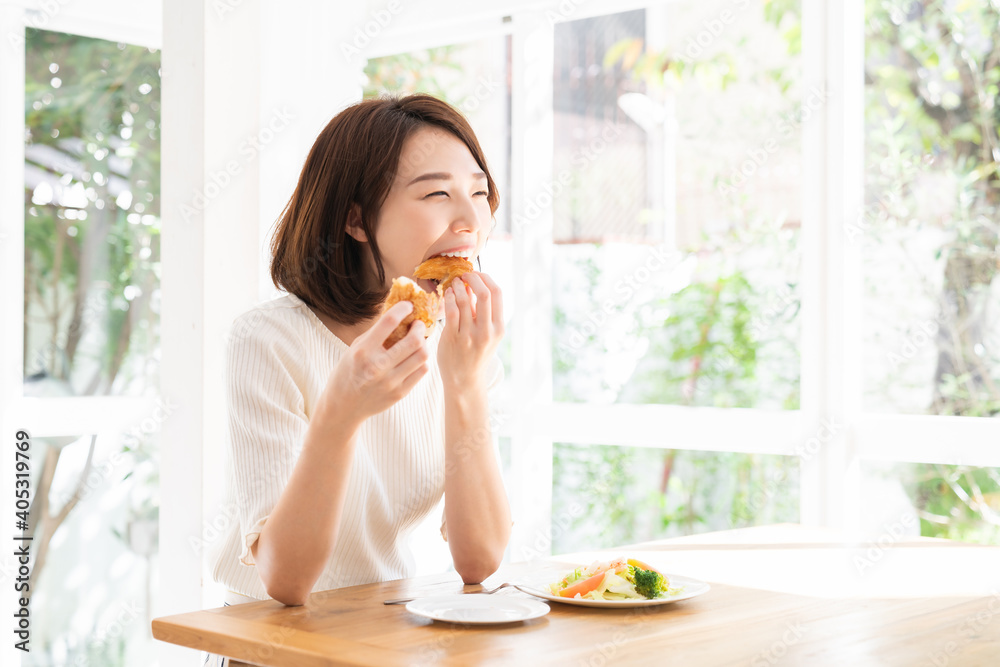 サラダとパンを食べる女性