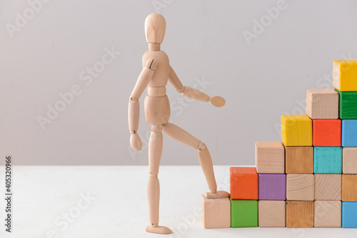 Stacked blocks with human figure on light background