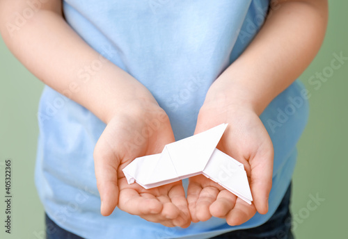 Child holding paper dove, c...