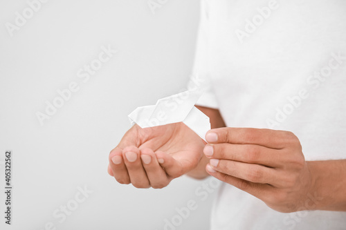 Male hands with paper dove on light background