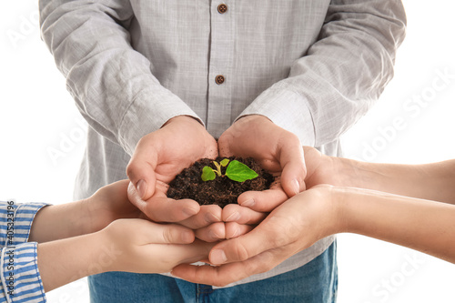 Hands of family with soil a...