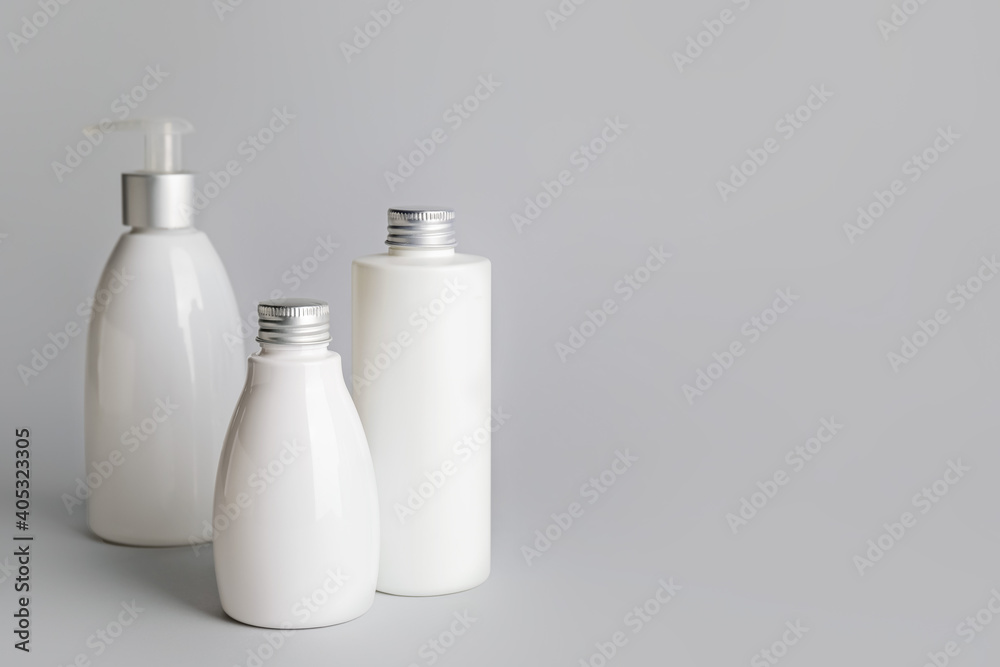 Different bottles of cosmetic products on gray background Different bottles of cosmetic products on gray background