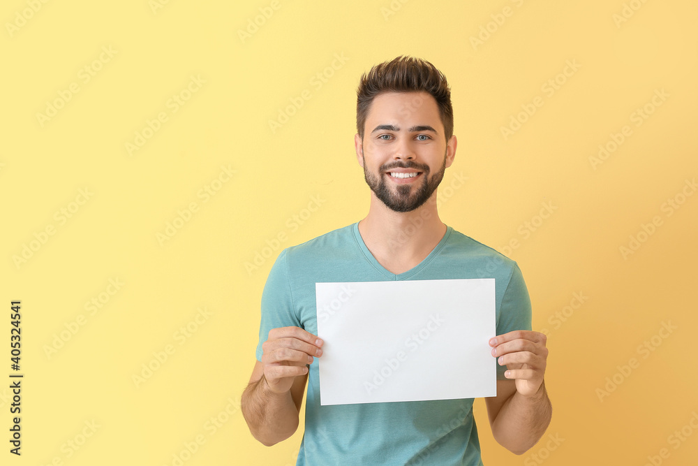 Young man with blank paper sheet on color background Young man with blank paper sheet on color background