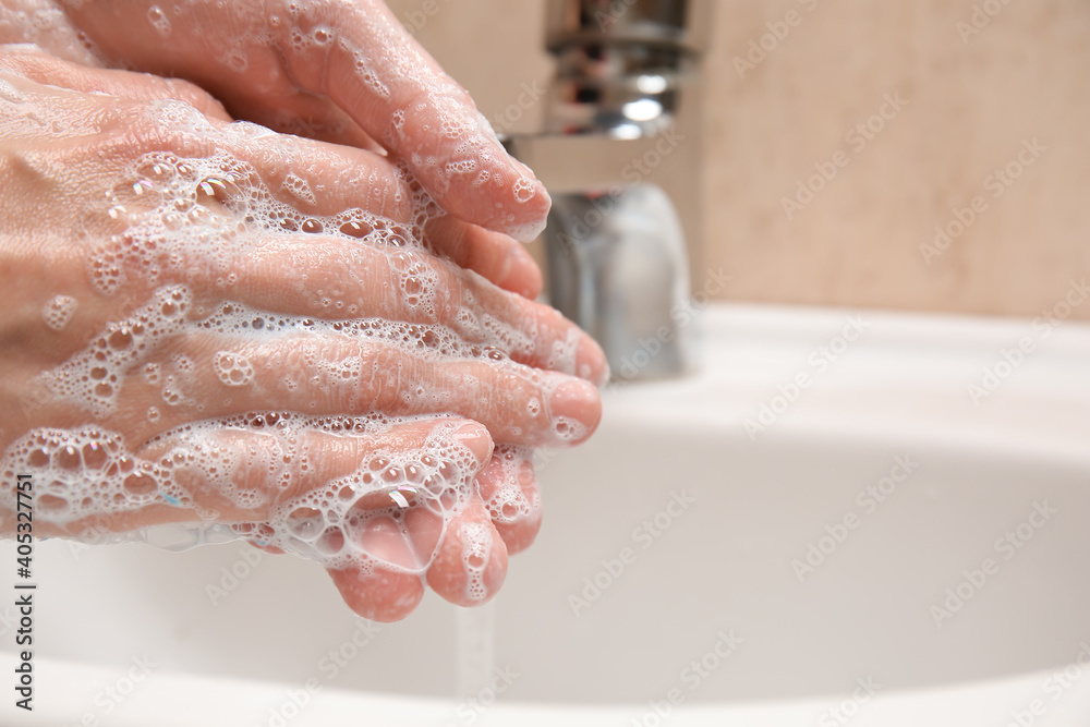 Young woman washing her hands in bathroom, closeup