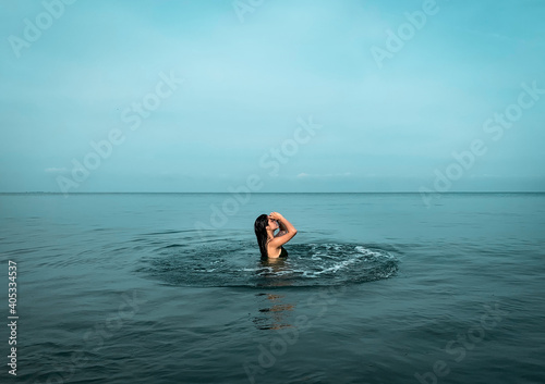 mujer vestido de baño en medio del mar 