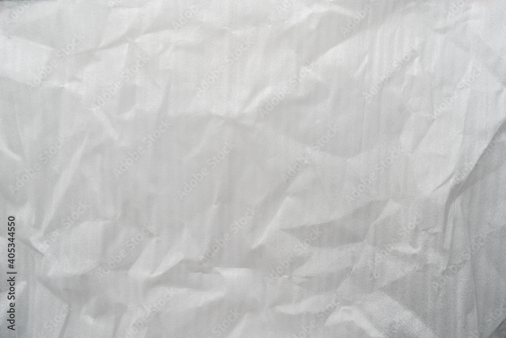 Crumpled white plastic foam foil texture perfect for background structure. Packaging material with rough wrinkles. The grunge textured surface can be used as backdrop.
