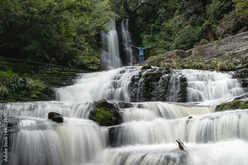 Man opening his arms at the majestic McLean falls. New Zealand, South Island