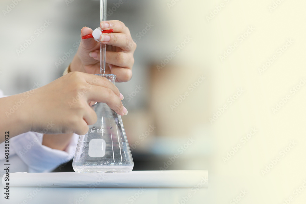 Scientist is holding burette and erlenmeyer flask. free space on right ...