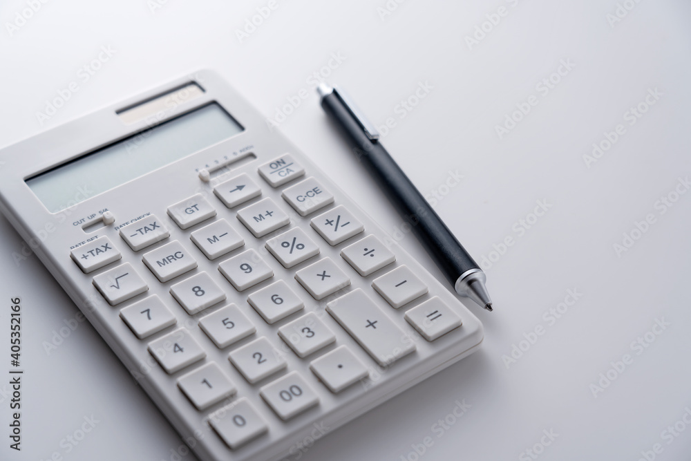 A calculator and pen on a white background A calculator and pen on a white background