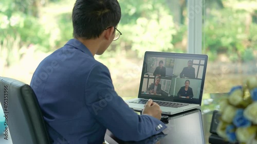 Work from Home concept, Back view of businessman talk with business partners using video call on laptop discuss project online. Asian team using laptop  online meeting.