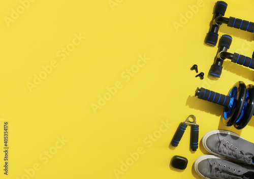 flat lay of sport and fitness equipment on yellow background with copy space. illuminating stay home training and workout concept.