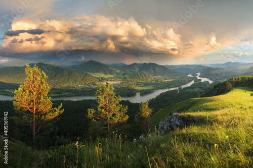 Thundercloud over the valley. The Katun River, Altai. Sunset light.