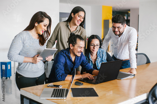 Group of latin business people working together as a teamwork while sitting at the office desk in a creative office in Mexico city photo