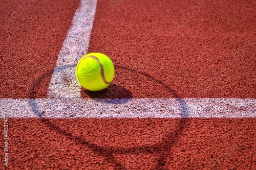 Shadow of net and racket surrounding a tennis ball © NetPix
