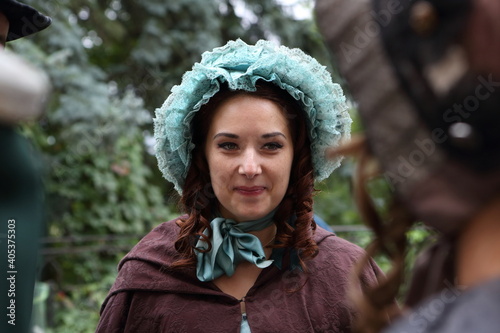 Obraz na plátně A girl in a 19th century outfit walks in the park