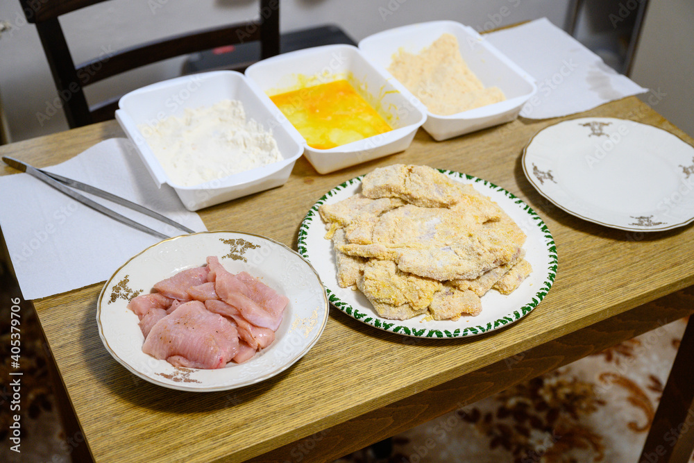 Chicken cutlets on a plate with a wrapping kit in the background. Chicken cutlets on a plate with a wrapping kit in the background.