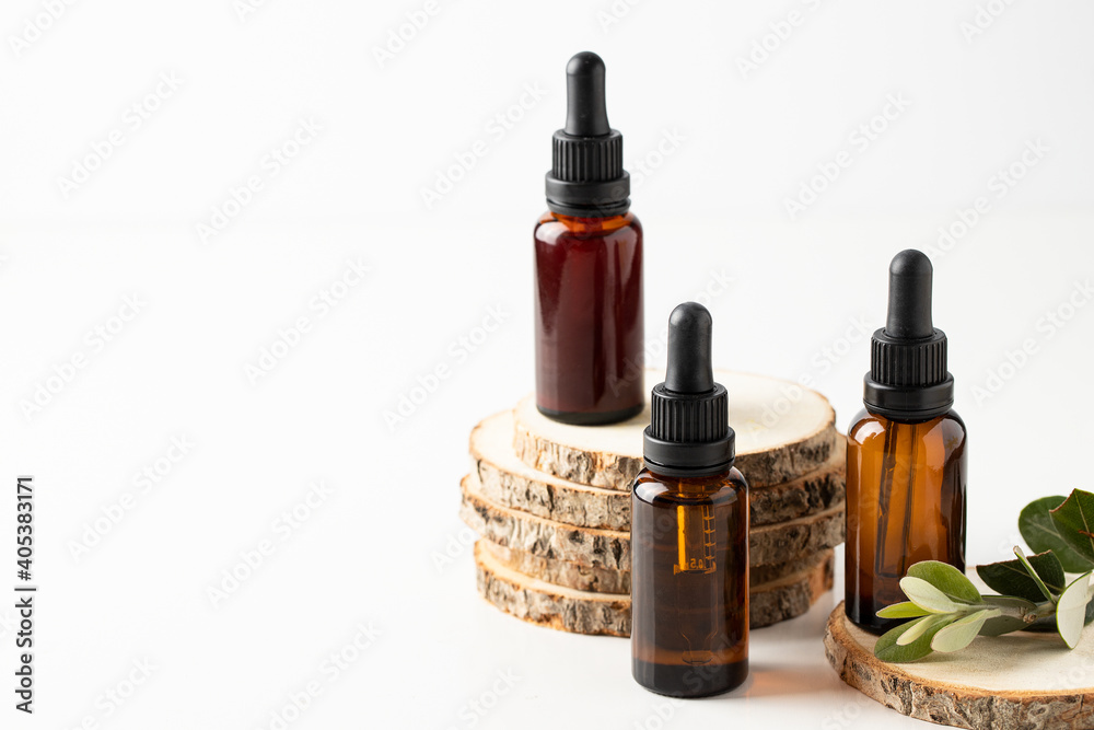 Naklejka premium Crystal dropper bottles with different essentials oil for healthy skincare. Natural cosmetic and substantiable eco packaging concept.