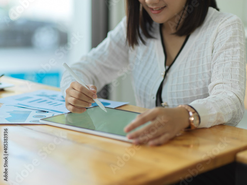 Businesswoman working with mock up digital tablet on wooden table