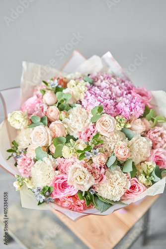 Beautiful bouquet of mixed flowers on wooden table. the work of the florist at a flower shop. Delivery fresh cut flower. European floral shop. © malkovkosta