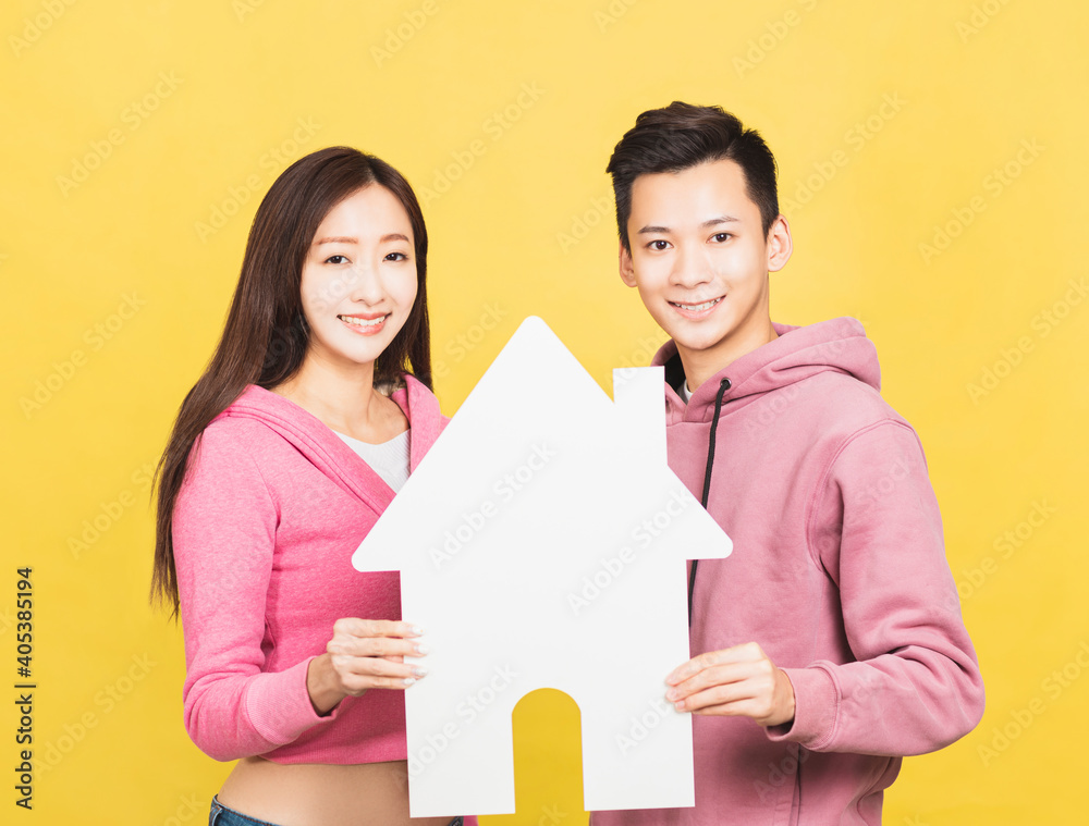 happy young couple holding a small house the in their hands. home and house concept happy young couple holding a small house the in their hands. home and house concept