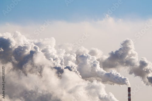 industrial chimneys with heavy smoke causing air pollution on the blue sky background