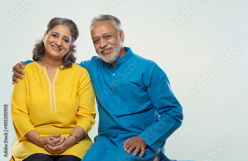AN SENIOR COUPLE HAPPILY LOOKING AT CAMERA AND SMILING	