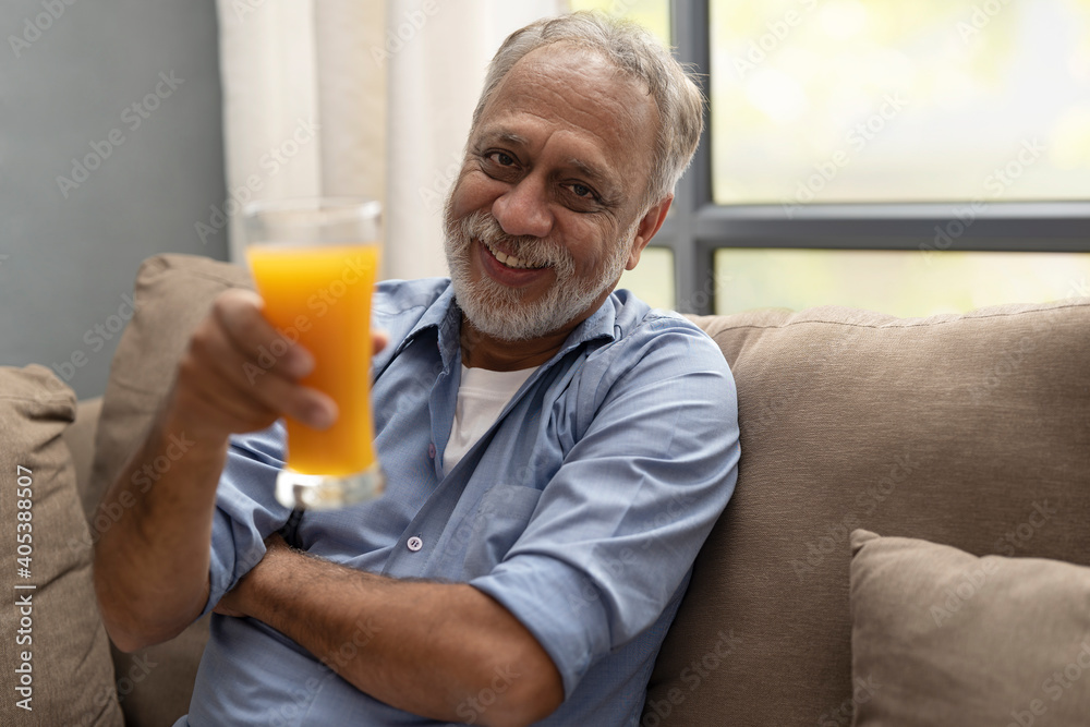 A HAPPY OLD MAN HOLDING A GLASS OF FRESH FRUIT JUICE A HAPPY OLD MAN HOLDING A GLASS OF FRESH FRUIT JUICE