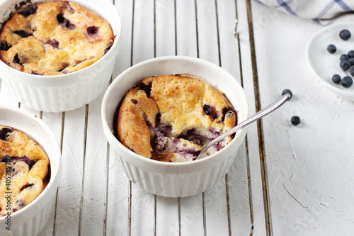 Cottage cheese casserole with blueberries in a portioned cup with a spoon