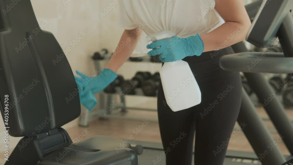Cleaning and disinfecting exercise machines in the gym. Prevention during the COVID-19 pandemic. Close-up. Cleaning and disinfecting exercise machines in the gym. Prevention during the COVID-19 pandemic. Close-up.