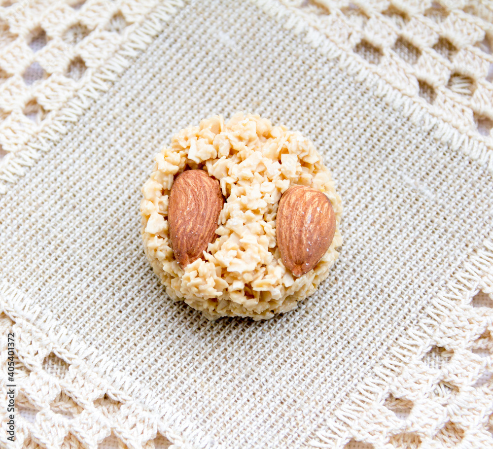 Very soft, creamy sweet candy with almonds on a light textile background