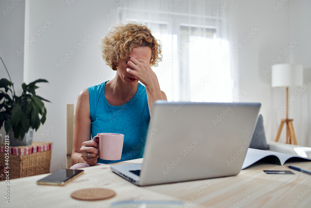 Woman working from home and being depressed, tired with headache. Modern concept and problems with freelancers. Woman working from home and being depressed, tired with headache. Modern concept and problems with freelancers.