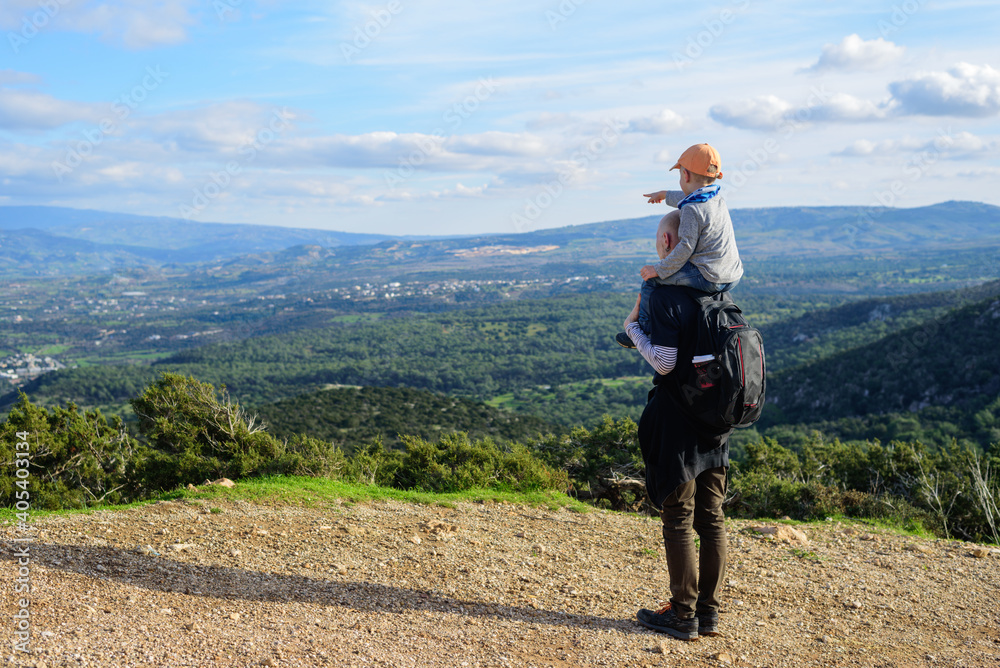Father and son walking in Cyprus mountains with stunning view to island Father and son walking in Cyprus mountains with stunning view to island