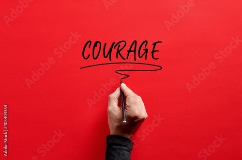 Принти на полотні Male hand writing the word courage on red background