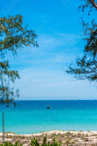VERTICAL wild beauty panorama shot skyline, pure blue azure tropical sea surface, no clouds clear sun shine sky, sailing boat. Tourism recreation after pandemic, summer vacation concept. Copy space