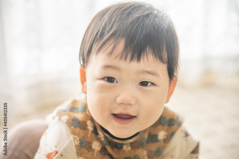 リビングでリモコンで遊ぶ赤ちゃん