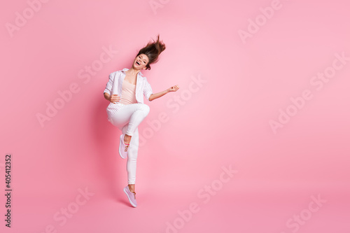 Full length photo of funny adorable young lady wear casual white outfit jumping dancing isolated pastel pink color background