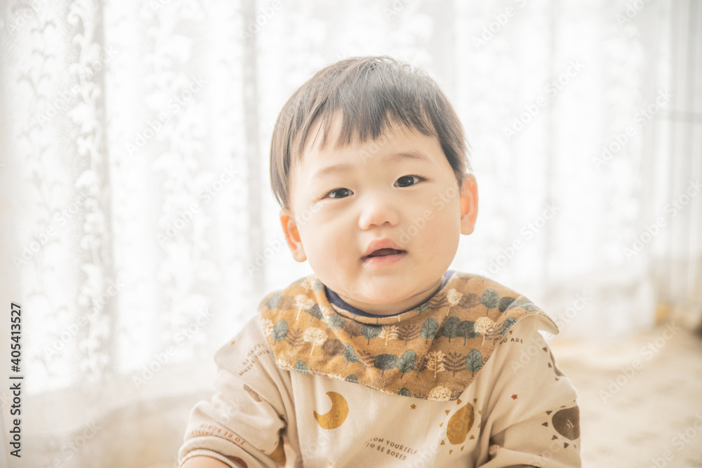 リビングでリモコンで遊ぶ赤ちゃん リビングでリモコンで遊ぶ赤ちゃん