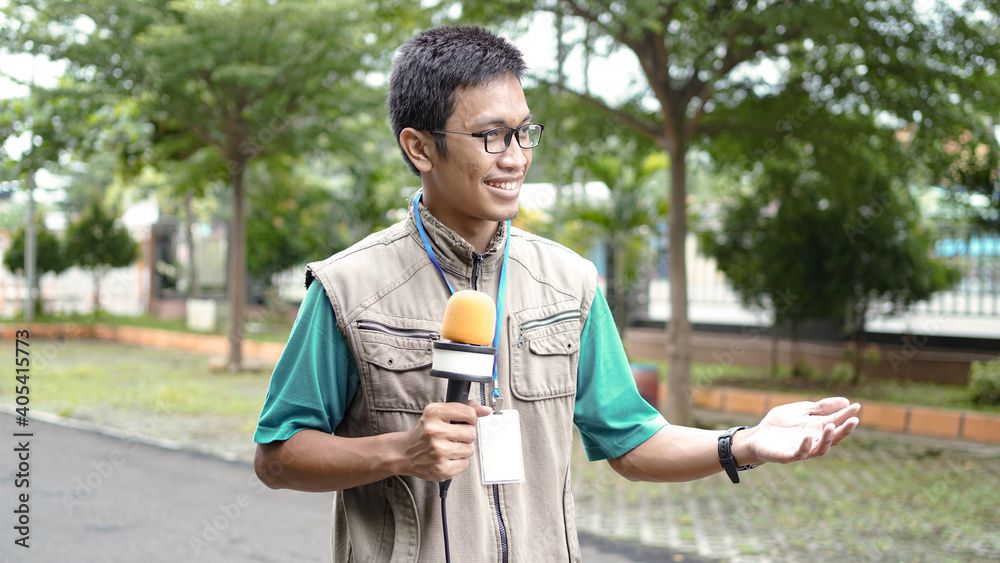 Fototapeta premium asian male journalist wear vest and ready for news