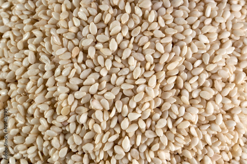 Close up of organic raw white sesame seeds on wooden background