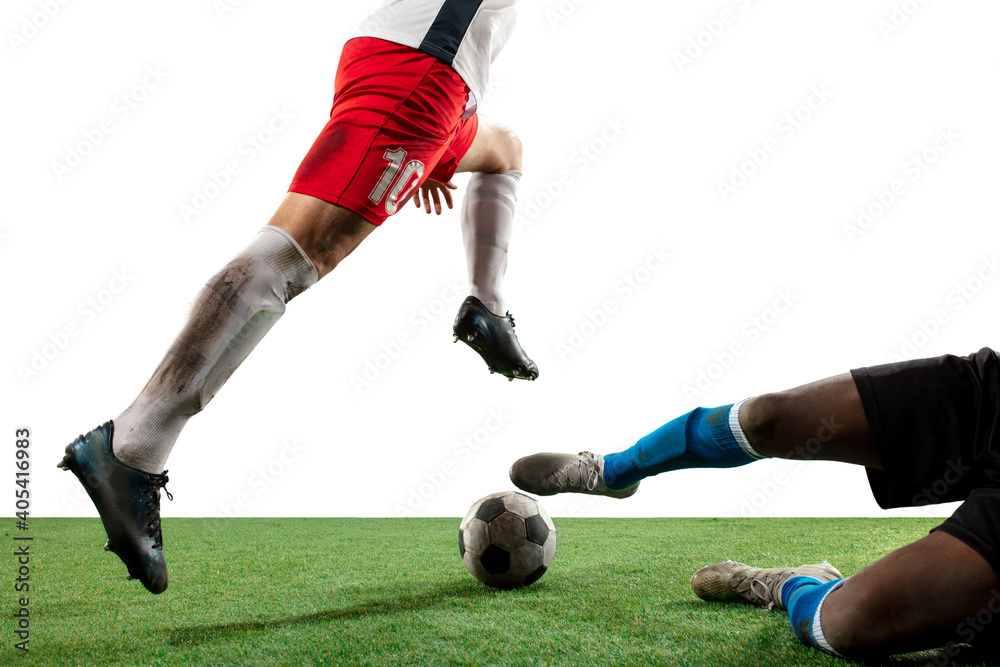Close up legs of professional soccer, football players fighting for ball on field isolated on white background. Concept of action, motion, high tensioned emotion during game. Cropped image. Close up legs of professional soccer, football players fighting for ball on field isolated on white background. Concept of action, motion, high tensioned emotion during game. Cropped image.