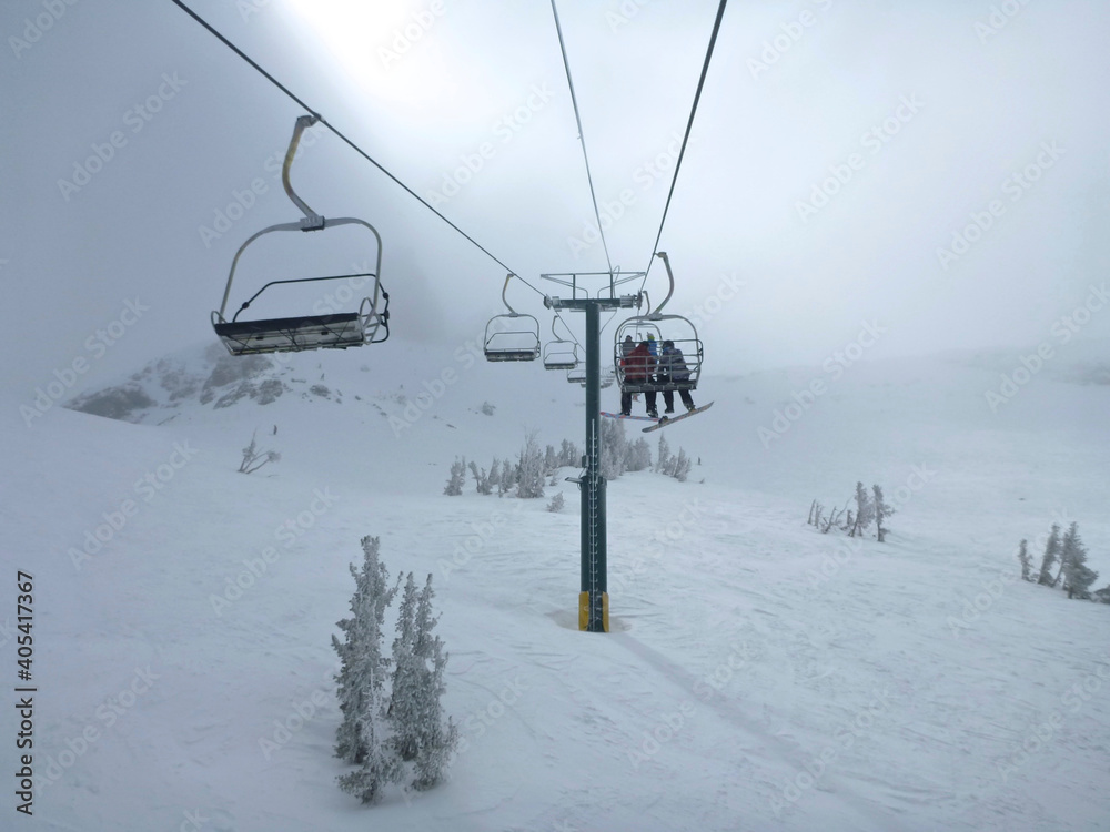 Moody view of the chair lift and extreme terrain at a ski resort in california on a cloudy day