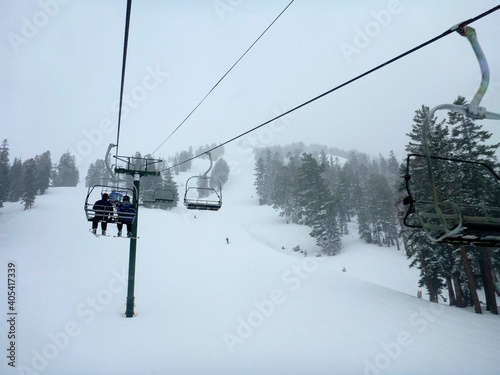 Moody view of the chair lift and extreme terrain at a ski resort in california on a cloudy day © Jen