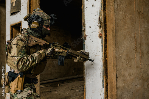 Special forces soldier doing tactical training in building clearing (CQB). He is wearing multicam uniform and assault rifle HK416.