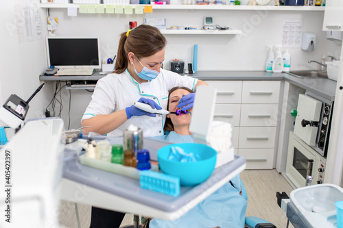 Young woman fixes her teeth by female dentist in dental office.